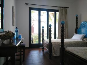 卡拉纳雅达Zhimbad B&B by the sea的一间卧室设有两张床、一张桌子和一个窗口。
