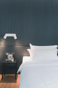 曼谷41Cafetel的一间卧室配有一张床和一个带床罩的床头柜。