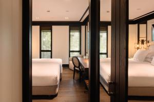 巴塞罗那Seventy Barcelona的一间卧室配有两张床和一张桌子及椅子