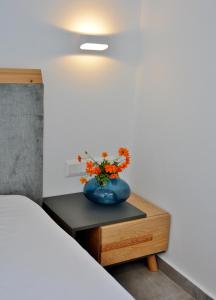 阿德里安诺斯坎波斯Christina Hotel的一张蓝色花瓶,在床边的桌子上放着鲜花