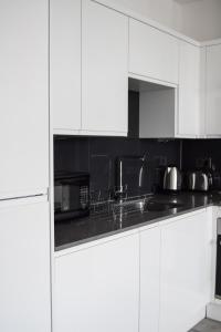 HornchurchMorland Apartments - Hornchurch的白色的厨房配有白色橱柜和水槽