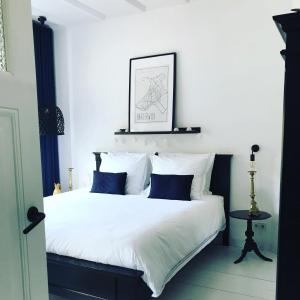 哈尔德韦克B&B Logeren bij Lies的一间卧室配有带白色床单和蓝色枕头的床。