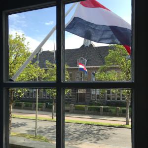 哈尔德韦克B&B Logeren bij Lies的建筑物前有旗帜的窗户