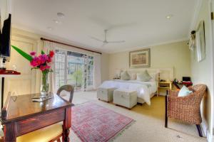 海姆维尔Moorcroft Manor Boutique Country Hotel的一间卧室配有一张床和一张鲜花桌子