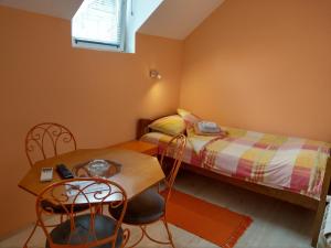 阿帕丁Apartment Harmonija apatin的一间卧室配有两张单人床和一张桌子及椅子