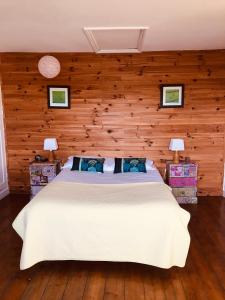 鲁贝阿布里杜帕桑特酒店的卧室设有白色的床和木墙