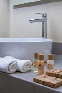 利马金色太阳套房酒店的浴室柜台配有毛巾和产品