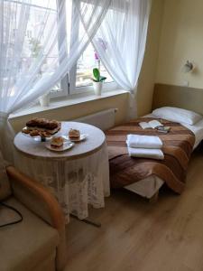 斯维德尼克费恩兹亚酒店的一间设有一张床铺的房间,配有一张桌子和食物