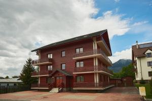 塔查斯卡-鲁穆尼卡Holiday apartment High Tatras的黑色屋顶的大型红色建筑
