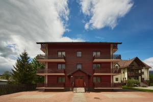塔查斯卡-鲁穆尼卡Holiday apartment High Tatras的一座带红色门的大型木制建筑
