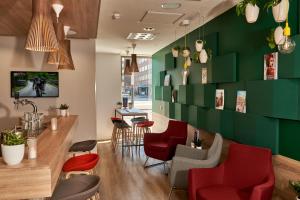 阿姆斯特丹阿姆斯特丹快捷智选假日酒店的餐厅设有红色椅子和绿色的墙壁