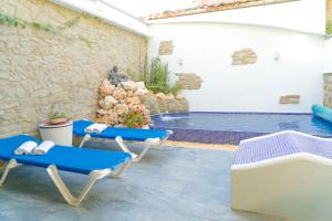 Santa Greu del JutglarLa Pausa Rural & Wellness的一个带蓝色椅子的庭院和一个游泳池
