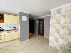 普什奇纳Apartament na Starówce III的厨房配有白色橱柜和黄色及灰色的墙壁