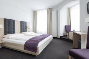 因特拉肯隆兹博酒店的一间卧室配有一张大床和一张书桌