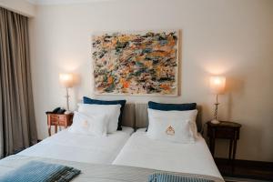 阿尔科巴萨查莱特冯特诺瓦酒店的一间卧室设有两张床,墙上挂着一幅画