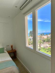 贝尼卡西姆Hogar en Benicasim的一间卧室设有2扇窗户,享有海景
