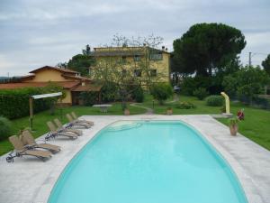 卡波罗纳Villa Casa Gemelli的一个带椅子的游泳池和一个背景房子