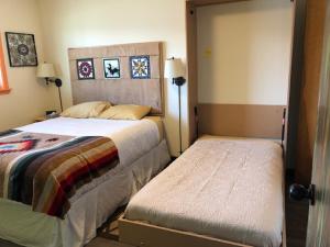 西沃德阿拉斯加视角旅馆的一间卧室设有两张床,一扇门通往房间