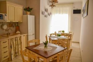 滨海波利尼亚诺Dimora delle Rondini的厨房以及带桌子和冰箱的用餐室