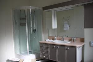 TonneinsLa Maison DUFFOUR chambres d'hôtes avec Petit Déjeuner的一间带玻璃淋浴和水槽的浴室