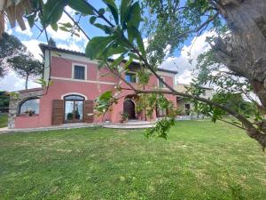 维泰博Antico Casale Edifizio的一座带绿色庭院的大型粉红色房子