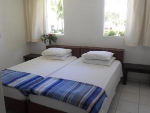 喀巴里特拉蓬塔公寓式酒店的带2扇窗户的小客房内的2张床