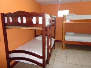AltagraciaHostal Rancho Sabor Isleño - Ometepe的客房设有三张双层床和一扇窗户。