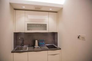 布赖代Al Aryam Serviced Aparthotel的厨房配有白色橱柜和水槽