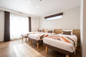 东京Eisei Stay的一间卧室设有三张床和窗户。