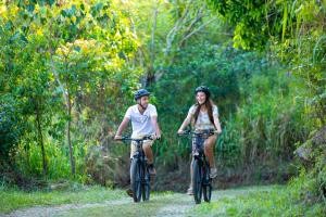 康提W15 Hanthana Estate Kandy的两个人骑着自行车沿着土路走