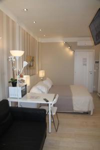 佩斯卡拉B&B Pescara Centro Luxury Suite的酒店客房配有一张床和一张沙发的书桌