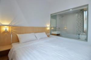 TanjungjohorT-ONE HOTEL的卧室设有一张白色大床和一扇窗户。