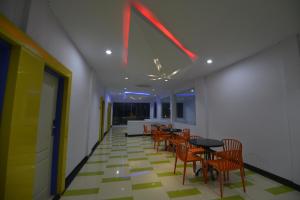 TanjungjohorT-ONE HOTEL的一间带桌椅和天花板的用餐室