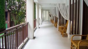 马尼拉Selah Garden Hotel Manila的带有桌椅的建筑走廊