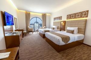 塞拉莱Hamdan Plaza Hotel Salalah, an HTG Hotel的酒店客房设有两张床和大窗户。