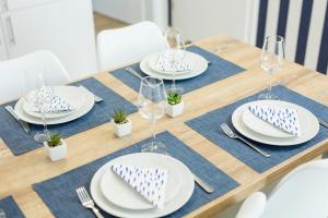 波德贝Apartament 19B Blue Marine Poddąbie的一张木桌,上面放有盘子和酒杯