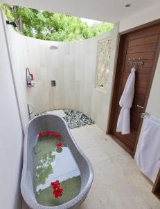 蓝梦岛努沙别墅酒店的带浴缸和窗户的浴室