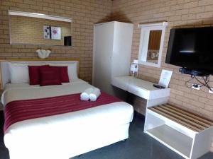 谢珀顿乡村之家汽车旅馆的一间卧室配有一张床和一台平面电视