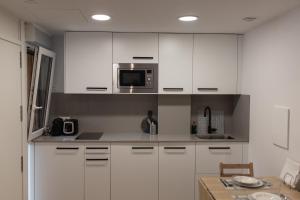 扎鲁亚斯Loft en Zarauz con parking Hator 1的厨房配有白色橱柜和微波炉
