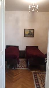 克瓦雷利Guest House Gzirishvili的一间设有两张床的客房,墙上挂着一幅画