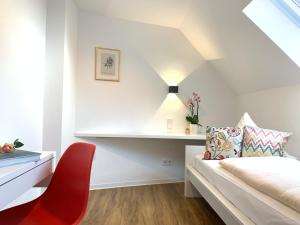 海德堡Hotel B54 Heidelberg City Center的一间卧室配有一张床和一张红色椅子