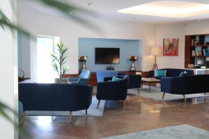 马亚波尔图机场酒店的客厅配有蓝色的椅子和桌子