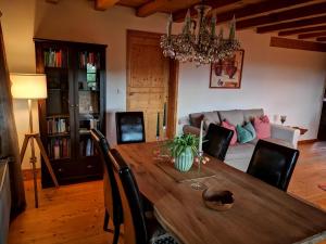 勒芬根Villa Grenzenlos的一间带木桌和沙发的用餐室