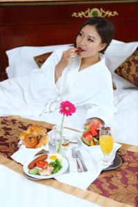 乌兰巴托王室酒店的躺在床上的女人,带上一盘食物