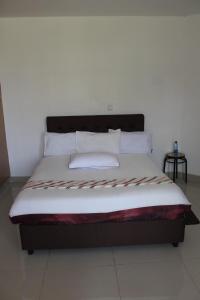 埃尔多雷特Salient Guest House的一张带白色床单和枕头的床
