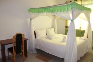 埃尔多雷特Salient Guest House的一间卧室配有一张带天蓬的白色床