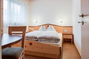 圣马蒂诺Hofschenke Pfeiftal - Heuduft的一间卧室配有一张带木制床头板和一张桌子的床。