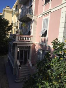 博尔迪盖拉Hotel Lucciola的粉红色的建筑,设有楼梯和阳台