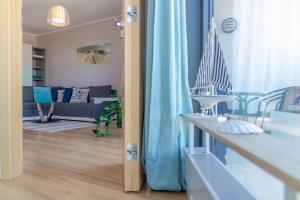 米兹多洛杰Horyzont by Baltic Home的客厅配有蓝色窗帘和沙发