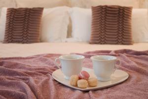 普拉托阿坎托阿尔中心住宿加早餐旅馆的床上有两杯和一盘饼干
